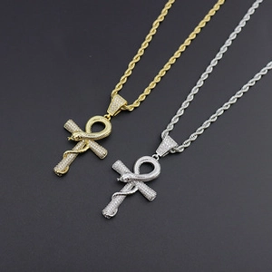 Detailed close-up of gold and silver Ankh cross pendants with snake motifs and AAA cubic zirconia