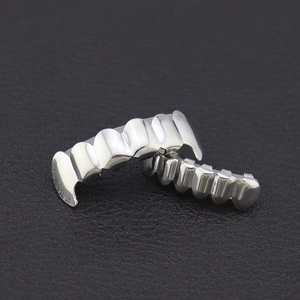 Polished silver hip hop teeth grillz set featuring classic wave design on leather background