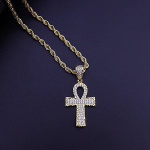 Macro shot of gold-plated Ankh cross pendant with pavé cubic zirconia and rope chain