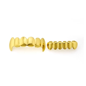Detailed view of polished gold plated hip hop teeth grillz set on white background