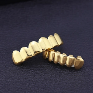 Polished gold-plated hip hop teeth grillz set for top and bottom rows on black leather