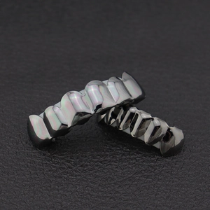 Close-up of iridescent hip-hop grillz with metallic purple and green finish on black leather