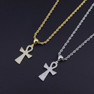 Détail macro de pendentifs croix Ankh en or et argent avec zircons et chaînes torsadées
