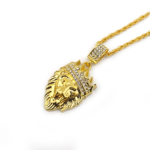 Dettaglio macro del ciondolo testa di leone hip hop con corona dorata e strass