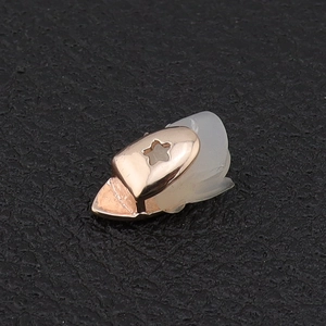 Close-up of rose gold hip hop single tooth grillz with a star cutout and silicone bar