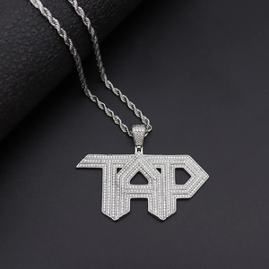 Λήψη macro του ασημένιου TAP hip hop μενταγιόν με ζιργκόν και στριφτή αλυσίδα σχοινιού