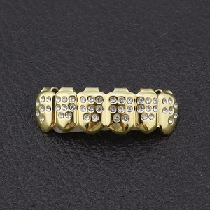 Macro-opname van vergulde hiphop grillz met sprankelende diamanten en siliconen
