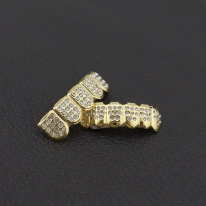Gedetailleerde macro-opname van goud vergulde hiphop grillz set bezet met witte kristallen