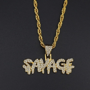 Macro shot of gold-plated SAVAGE hip hop pendant with sparkling crystals on rope chain