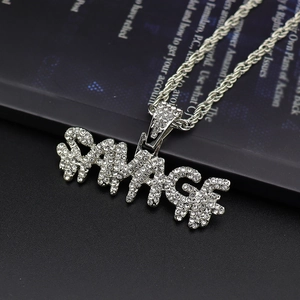 Macro shot of silver hip-hop SAVAGE pendant with pave rhinestones and rope chain