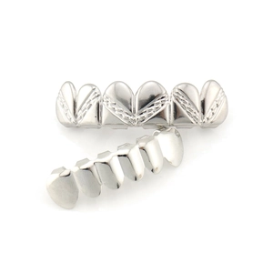 Dettaglio macro dei grillz hip-hop lucidati argento con struttura a 6 denti e trama a cuore