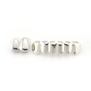 Close-up of silver-tone hip-hop grillz set with 2-tooth and 6-tooth polished metal pieces