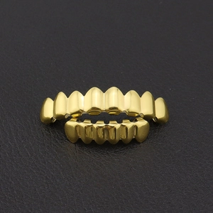 Vista macro de dentadura grillz hip hop bañada en oro sobre fondo de cuero negro