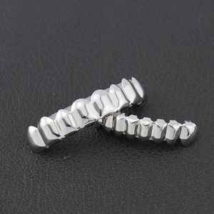 Macro shot of silver hip hop grillz set for upper and lower teeth on black leather