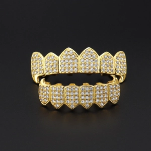 Iced out gold hip hop grillz set with micro paved zircon stones on black background