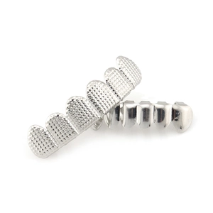 Macro-opname van zilveren hiphop grillz met rasterstructuur en gepolijste spiegelafwerking