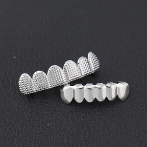 Detail van zilveren hiphop grillz-set met roostertexturen en gepolijste spiegeloppervlakken