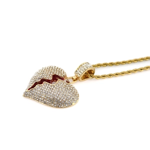 Close-up of hip hop iced out broken heart pendant with red enamel crack and rope chain