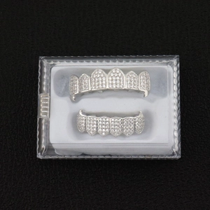 Detail view of silver hiphop grillz set with sparkling white zircons in a plastic box