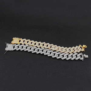 Dettaglio macro di bracciali cubani da 20mm in oro e argento con strass scintillanti
