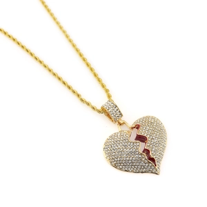 Detailed macro shot of iced out broken heart pendant with crystals and red enamel accent