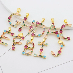 Detailed view of gold plated copper pendants with colorful zircon capital letters A to J