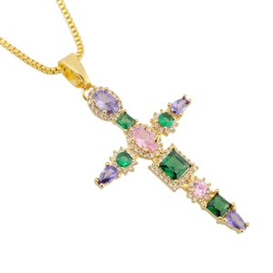 Macro shot of gold-plated cross pendant with vibrant multi-colored pear-shaped zircons