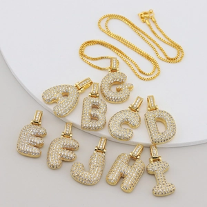 Detailed view of gold-plated hip hop alphabet pendants with micro-pave cubic zirconia stones