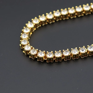 Macro della catena tennis dorata da 5mm con zirconi incastonati a quattro griffe per gioielli