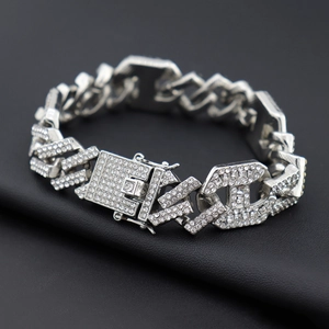 Vue macro du bracelet à maillons cubains argentés sertis de cristaux avec fermoir lettre H