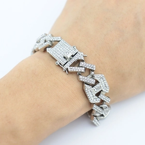 Détail du bracelet à maillons cubains argenté avec cristaux et fermoir de montre au poignet