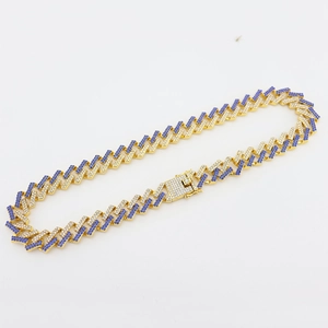 Detail of 15mm gold Cuban link chain with blue and white zircons in Z-shape design