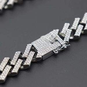 Detailed macro shot of a silver iced-out Miami Cuban chain with a diamond box clasp