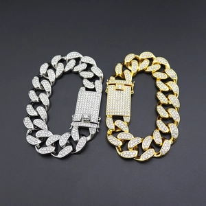 Detailed close-up of 20mm gold and silver iced out Cuban link bracelets with diamond clasp