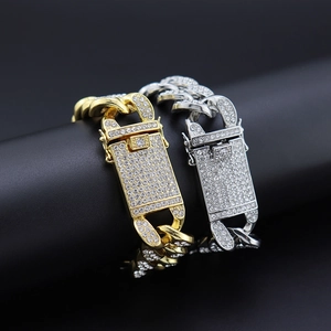 Detail shot of iced out Cuban link bracelets in gold and silver with diamond clasps