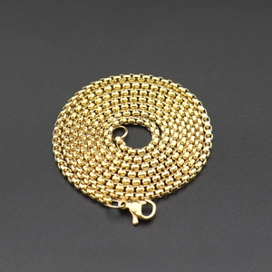 Détail d'un collier chaîne box en acier inoxydable doré avec fermoir mousqueton