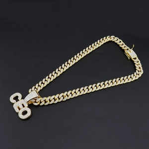 Detail of gold-plated iced out CEO pendant on iced out Cuban link chain necklace