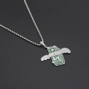 Gros plan d'un collier hip hop argenté avec pendentif dollar ailé et zircons verts