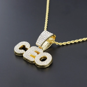 Close-up of gold iced-out CEO pendant necklace with micro-pave crystals and rope chain