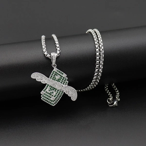 Détail macro du pendentif dollar ailé orné de zircons cubiques verts et blancs brillants