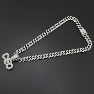 Close-up of iced out CEO letter pendant with silver Cuban link chain and rhinestones