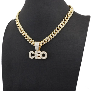 Close-up of golden iced-out CEO pendant on a Cuban link chain for men on a black bust