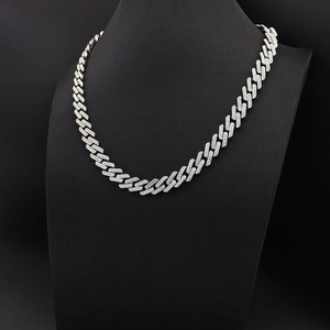 Détail d'une chaîne cubaine 13mm en argent sertie de diamants sur un présentoir noir