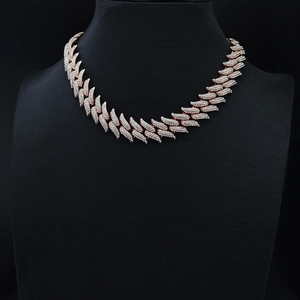 Macro shot of 19mm rose gold Cuban link necklace with iced out crystals on black display