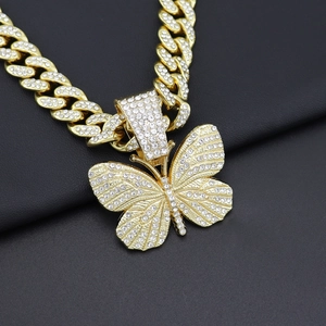 Macro shot of gold hip-hop Cuban link chain with a massive iced-out butterfly pendant