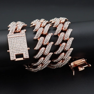 Iced out rose gold 19mm Cuban link chain with sparkling crystals on a black display stand