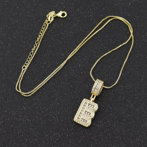 Détail du pendentif lettre B dorée avec zircons sertis et poinçon en argent S925