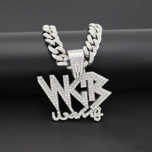 Vue macro de la chaîne cubaine argentée et du grand pendentif lettre WKB avec strass