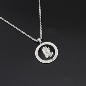 Macro view of hip hop prayer hands pendant with white zircon detailing on a rope chain