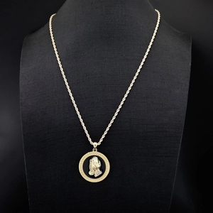 Detail of hip hop gold twist chain and praying hands pendant with crystal accents